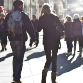 People walk along a sunlit street