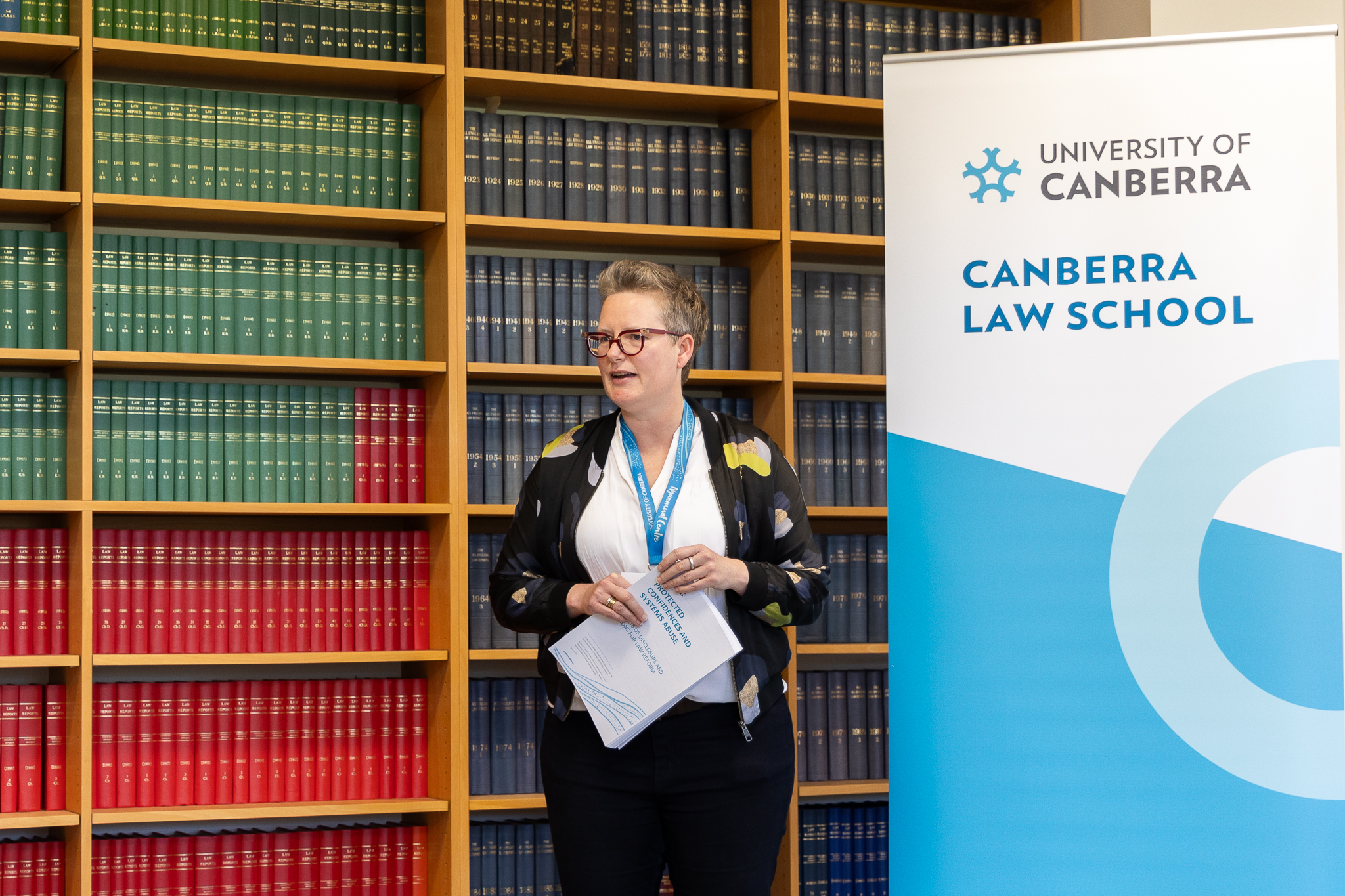 woman standing in front of law books