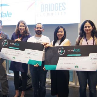 University of Canberra researchers holding their prize cheques after winning three prizes at the InnovAGE hackathon