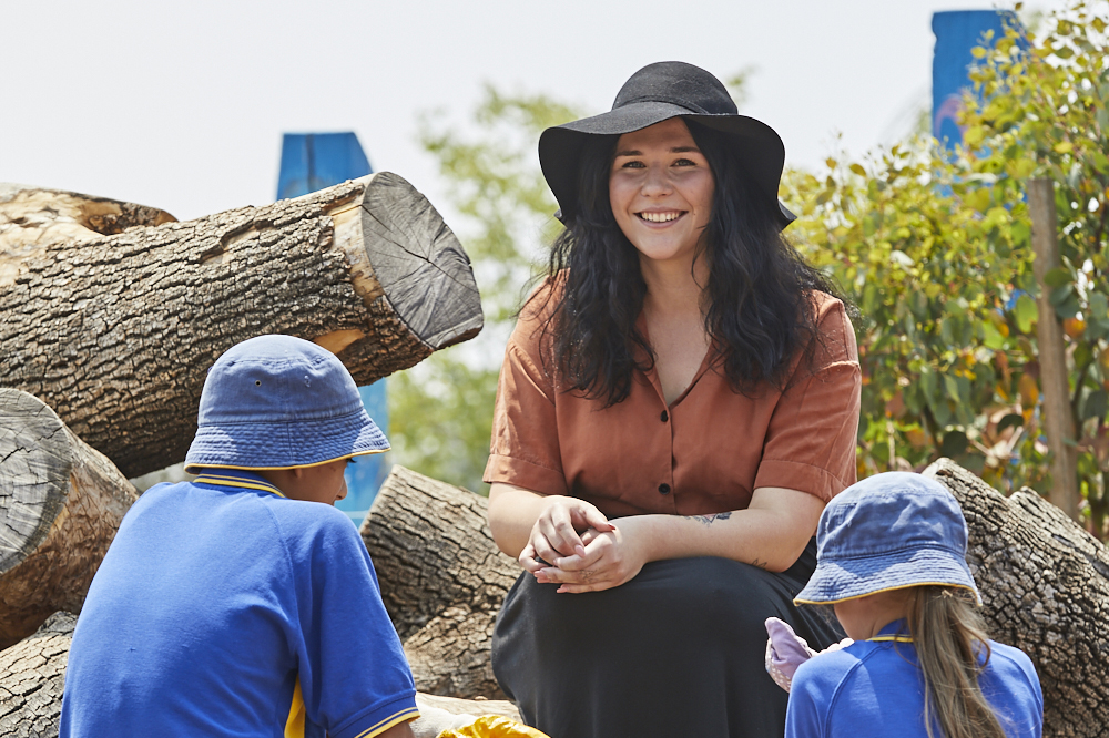 Young woman facing primary school children