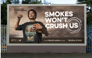 A billboard with a young boy which says Smokes won't crush us