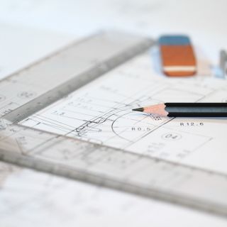 An architects drawing board, with rulers, pencils and schematics