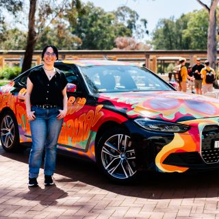 Woman standing in front of a colourful BMW