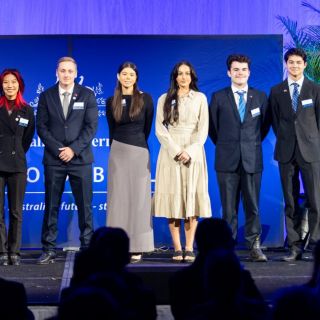 Award recipients pose for a photo on a stage