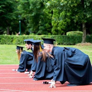 Students lining up for a race in graduation gowns