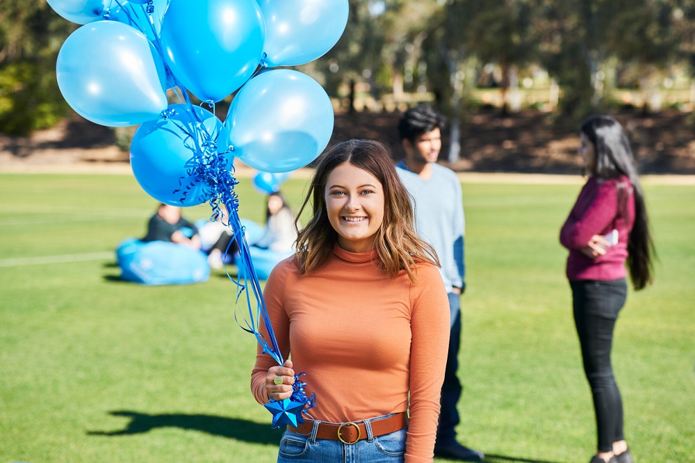 student with balloons