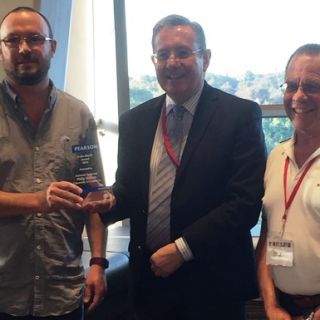 Philip Roberts accepts the Colin Marsh award from Garry McLean and past winner Kevin Lowe
