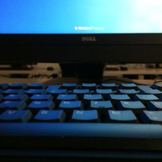A computer and keyboard in a dark room