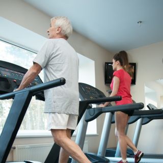An older person using a treadmill at a gym