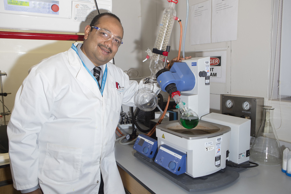 Dr Ghanem with the machine which helps remove the solvent, the catalyst currently appears as a green liquid.
