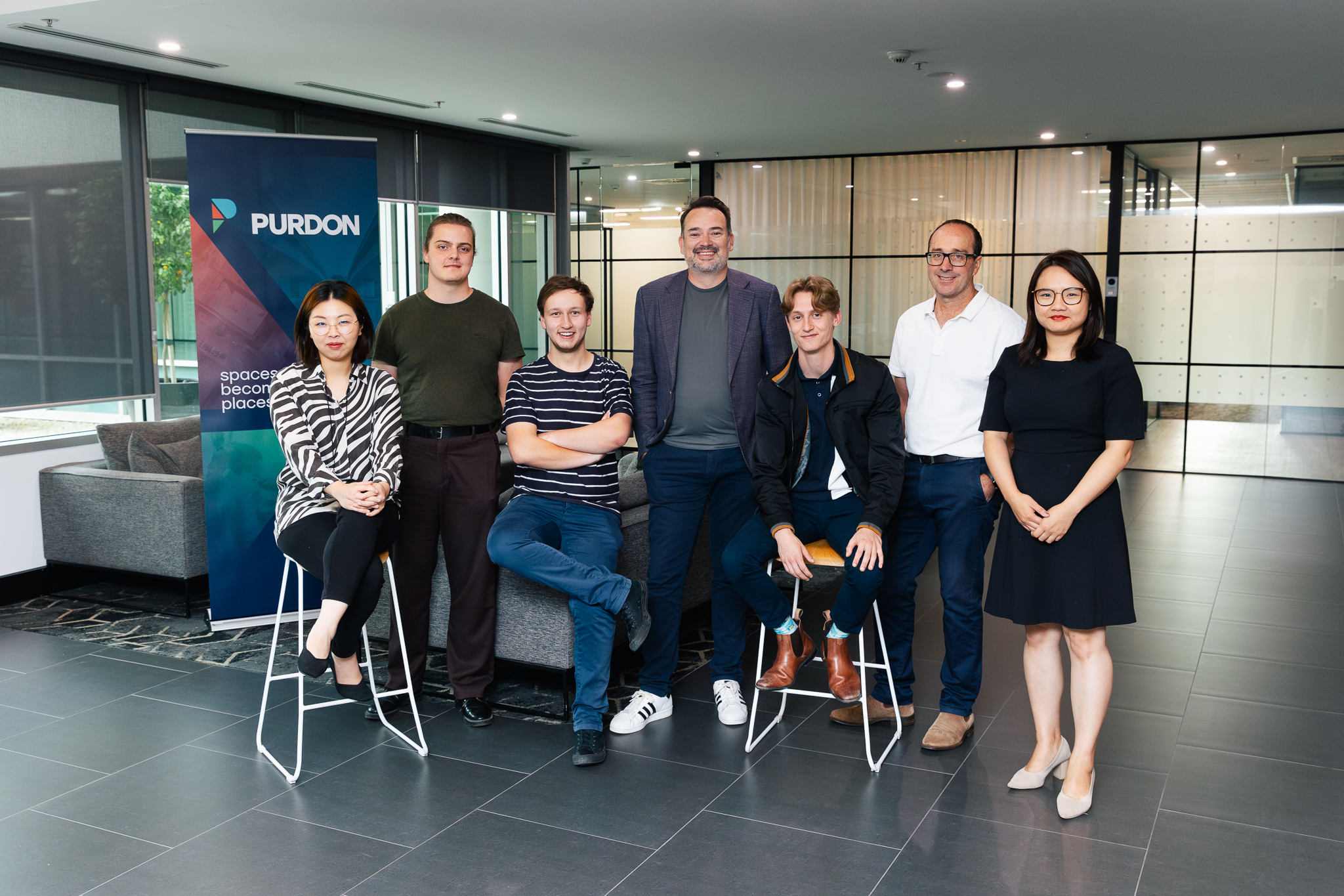 Group of staff standing in front of company banner