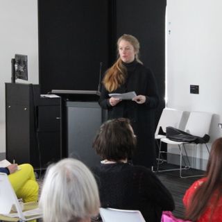 Poet and researcher Monica Carroll addresses the crowd of more than 50 at the Poetry on the Move Symposium