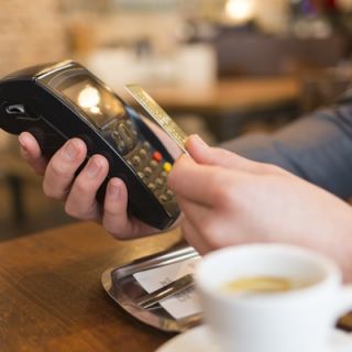 A person pays using contactless technology at a coffee shop