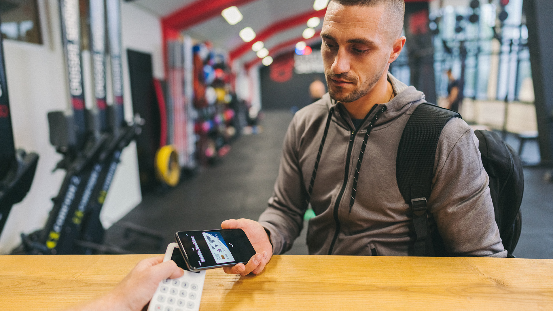 Man using his phone to pay for his gym session at UC.