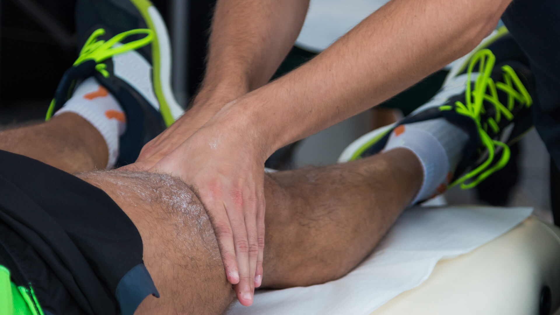 hands providing physiotherapy treatment on athlete knee