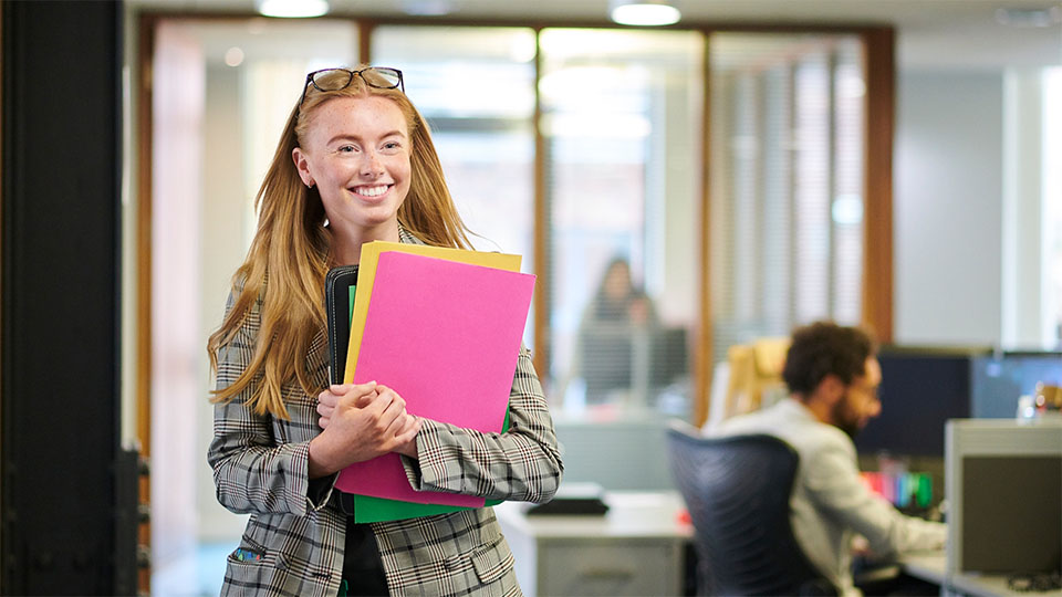 Two women studying a Bachelor of Business degree looking at a tablet