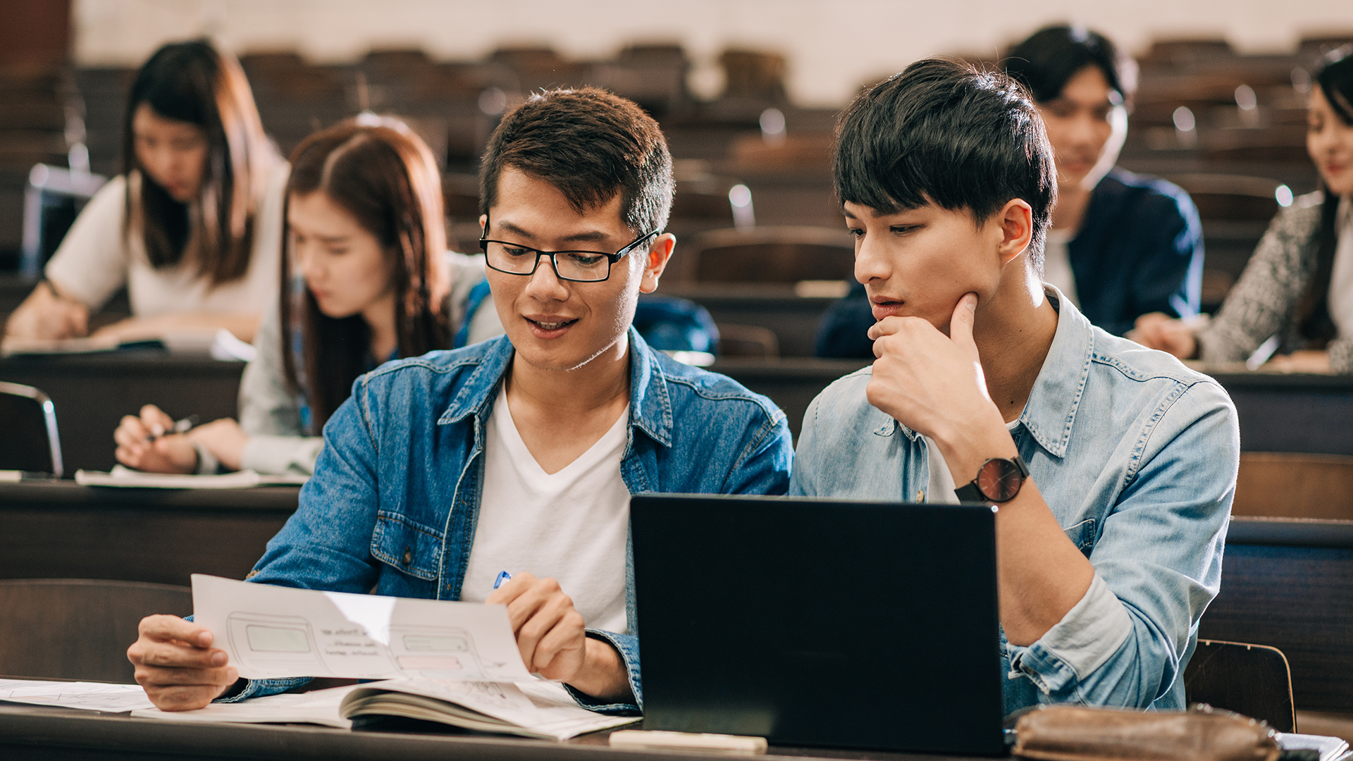 Two students in a lecture hall